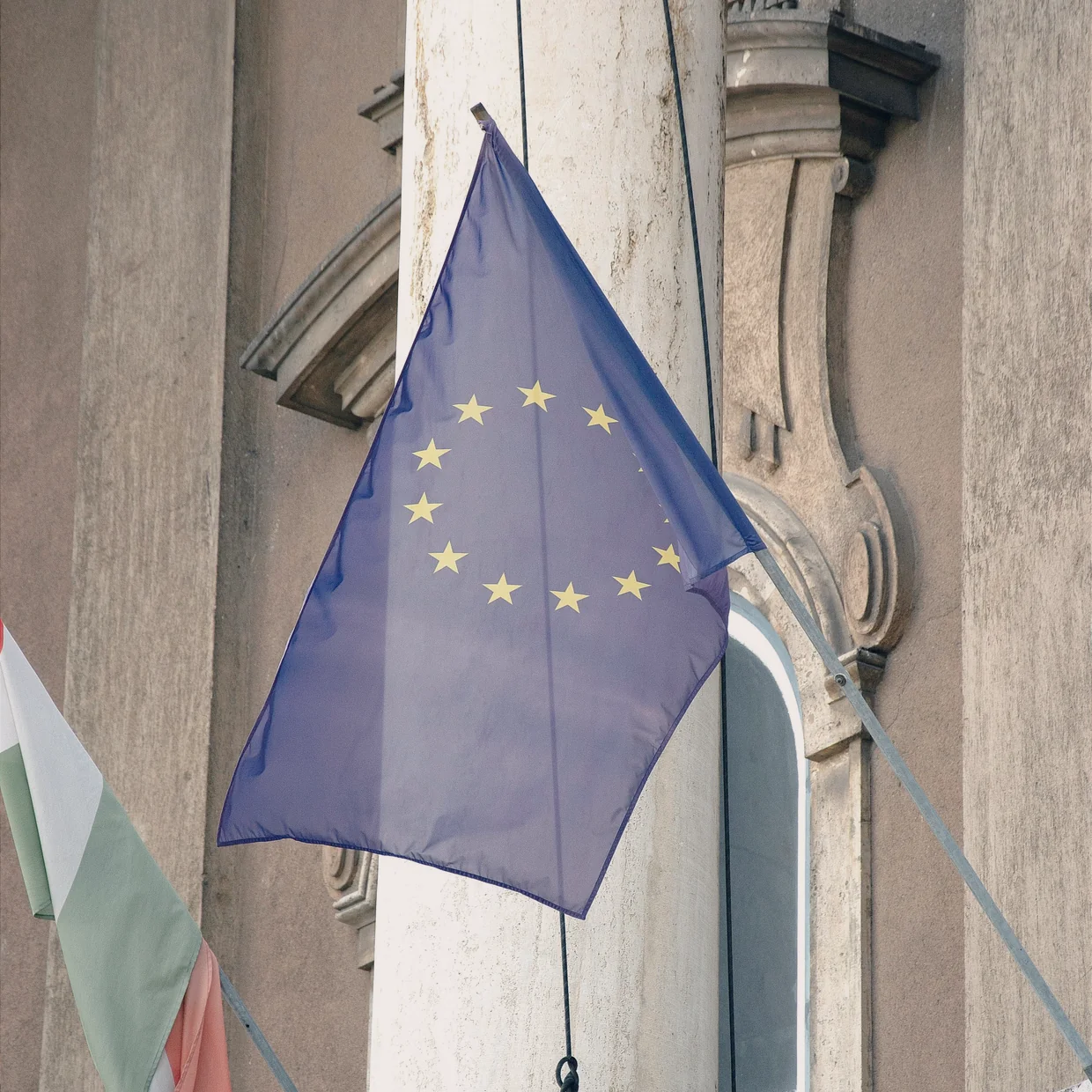 The EU flag on a stone facade.